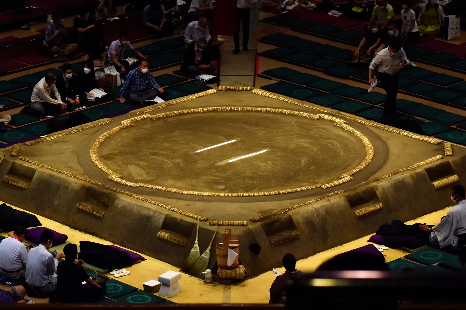 A sumo ring seen from above, with a circle of rice-straw bales on a raised clay platform in an arena